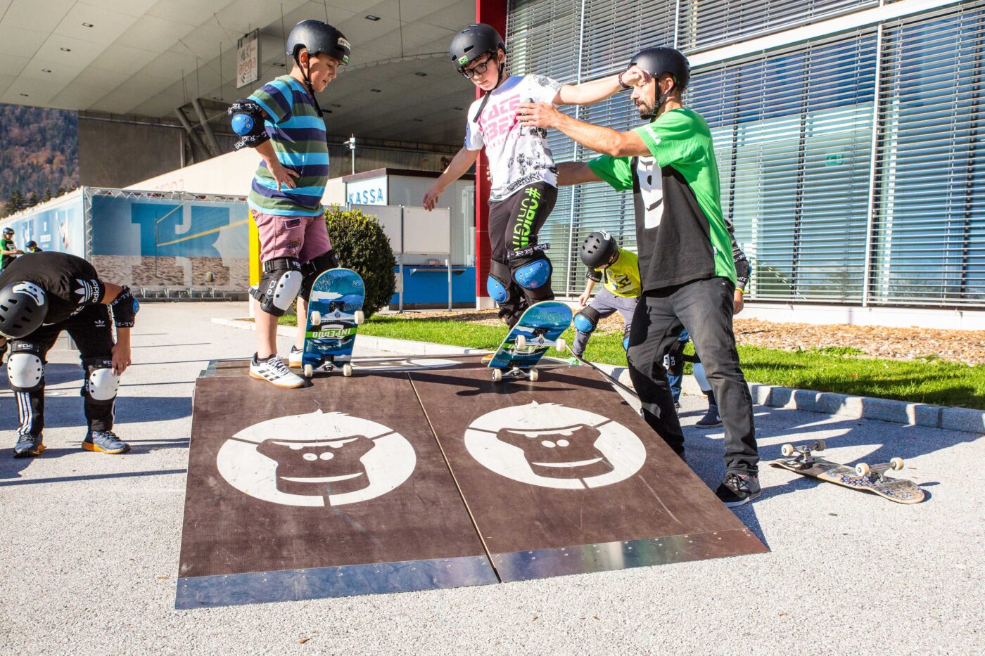 GORILLA Botschafter hilft 2 Knaben auf dem GORILLA Playground zu Skaten.